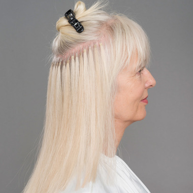 Bogenförmig wird eine Haarpartie über den gesamten Hinterkopf abgetrennt:  (© © Great Lengths)